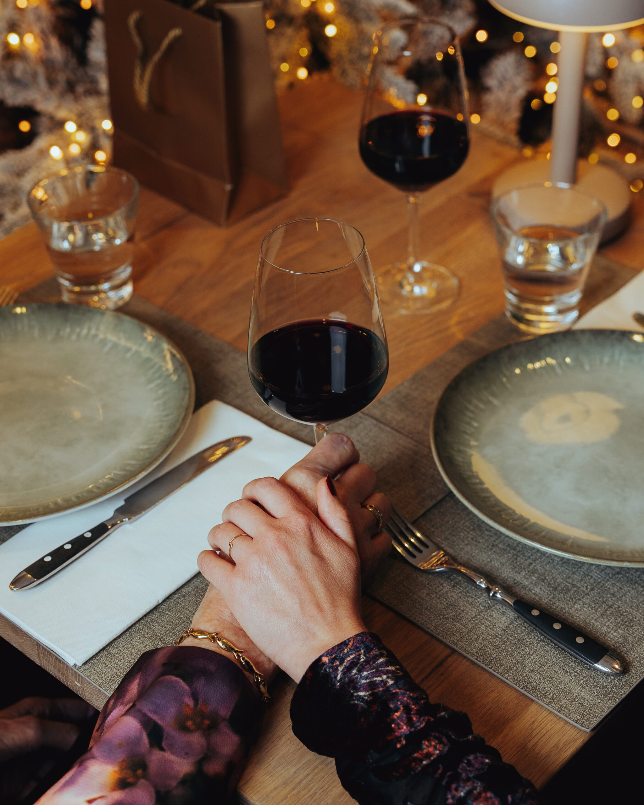 Twee generaties aan kerst tafel setting met proostmoment en liefdevolle aanraking